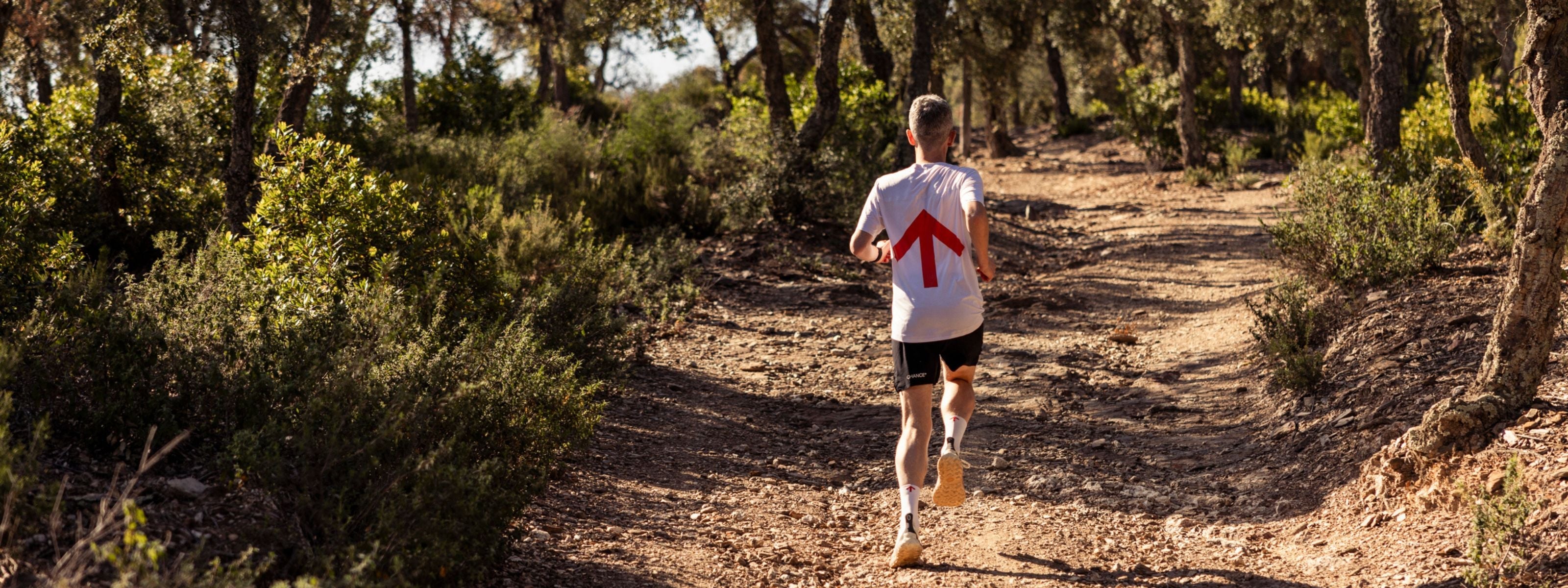 Person running on a trail in a forested area