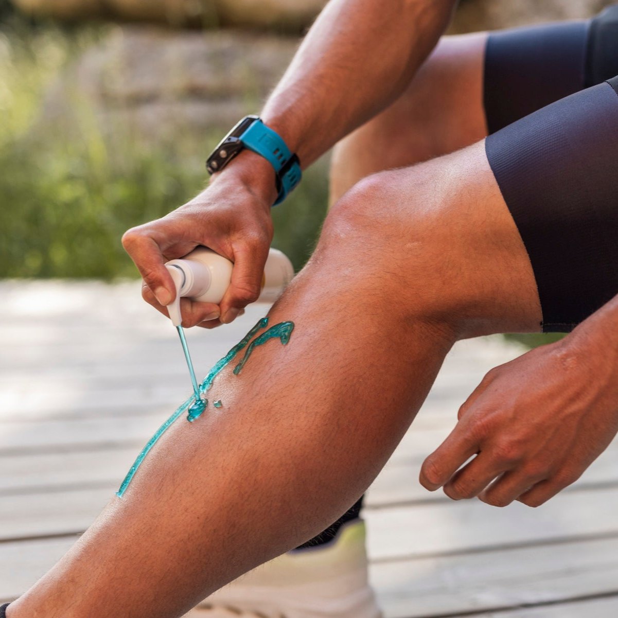 Person applying Pelotan Après recovery balm to their left leg.