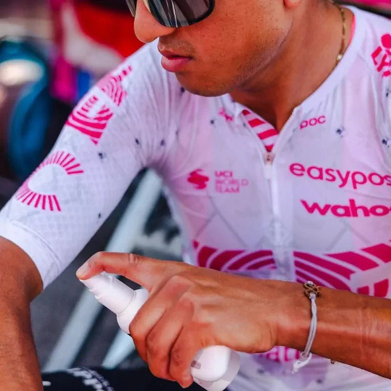 A rider from EF Pro Cycling is applying Pelotan performance sunscreen at the team bus befor a stage of the 2025 Tour of Italy.