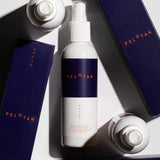 An artistic flat-lay image of the Pelotan 200ml bottle, surrounded by the box that the product arrives in.