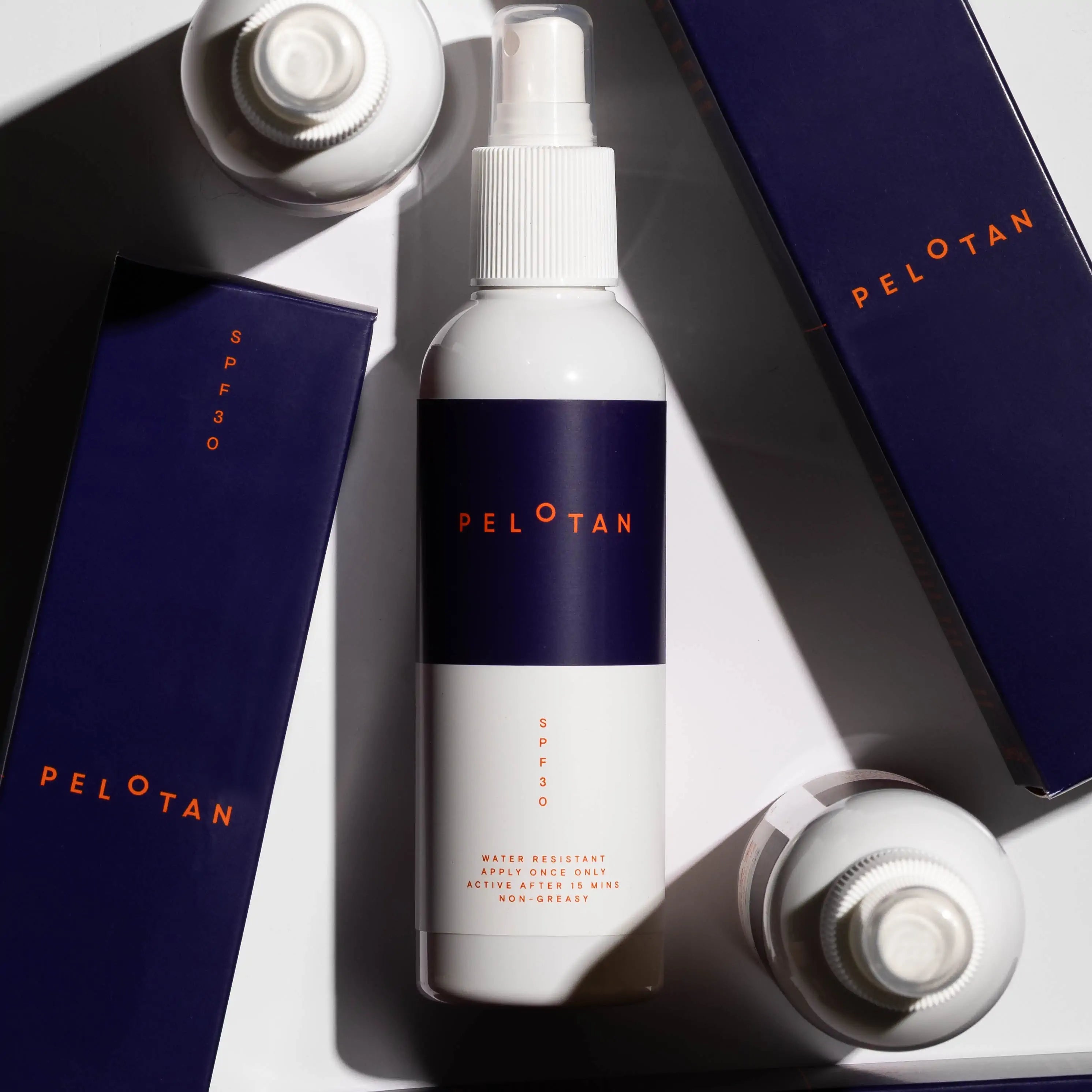 An artistic flat-lay image of the Pelotan 200ml bottle, surrounded by the box that the product arrives in.