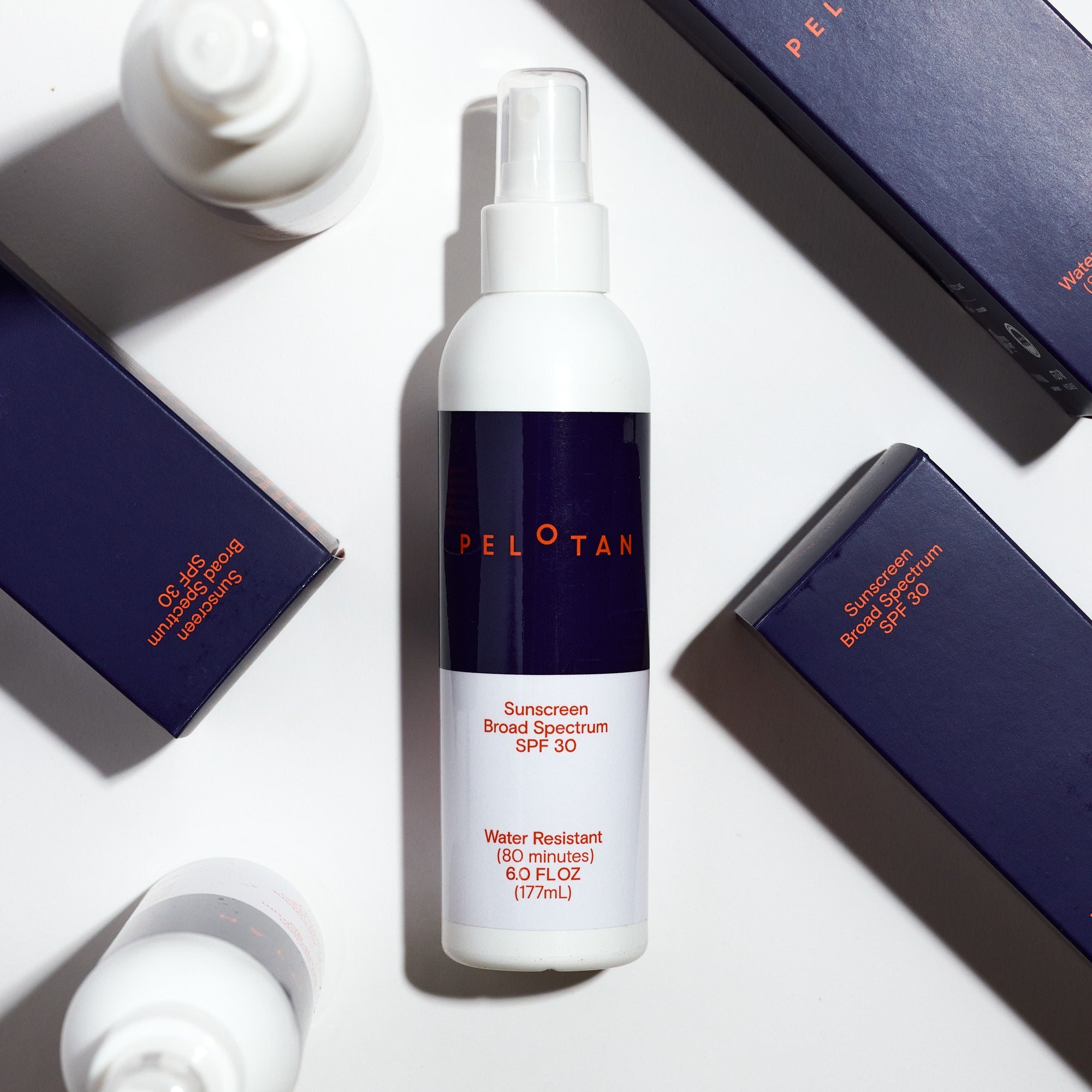 Peloton sunscreen bottle with packaging on a white surface