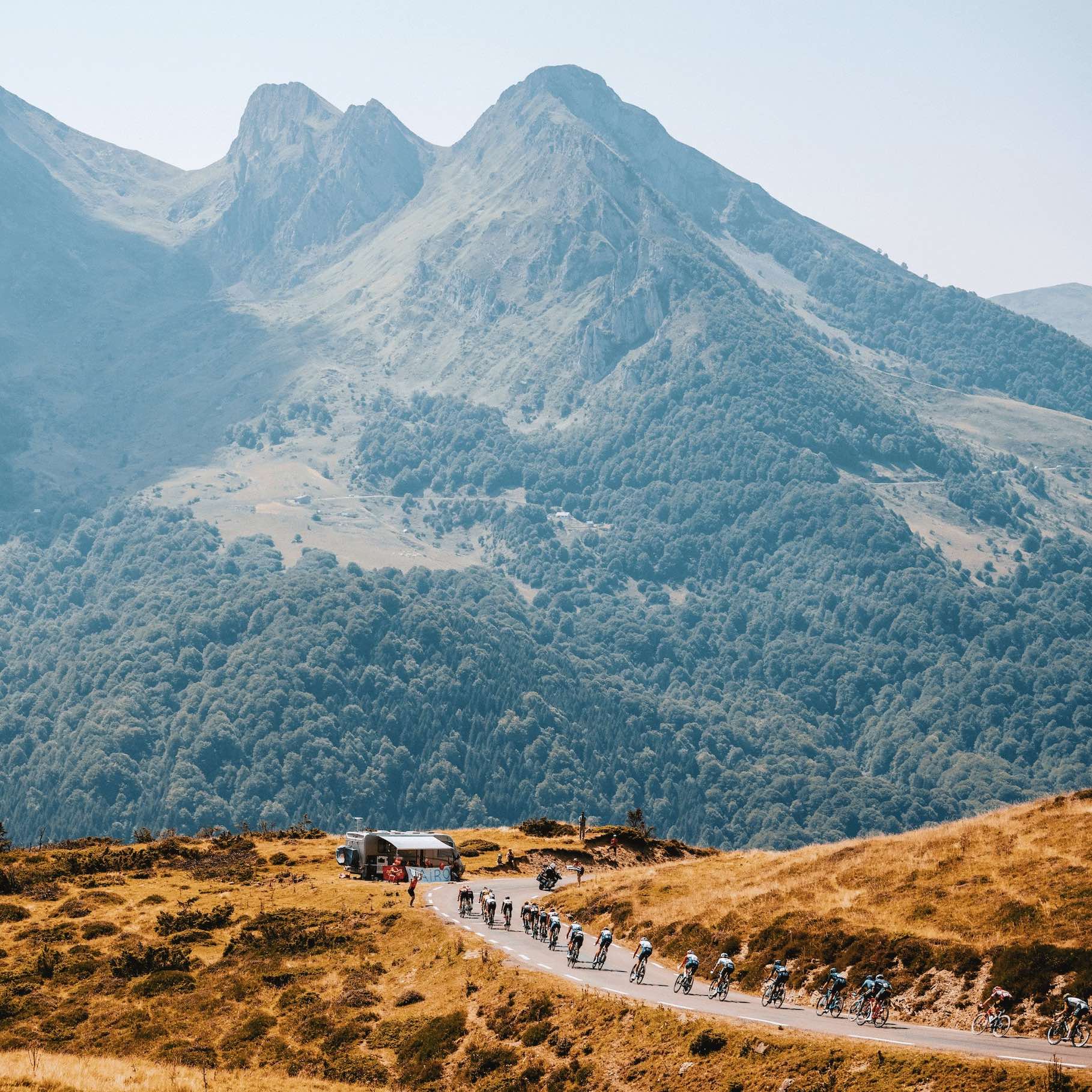 Group of cyclists on a mountain road with scenic mountains in the background