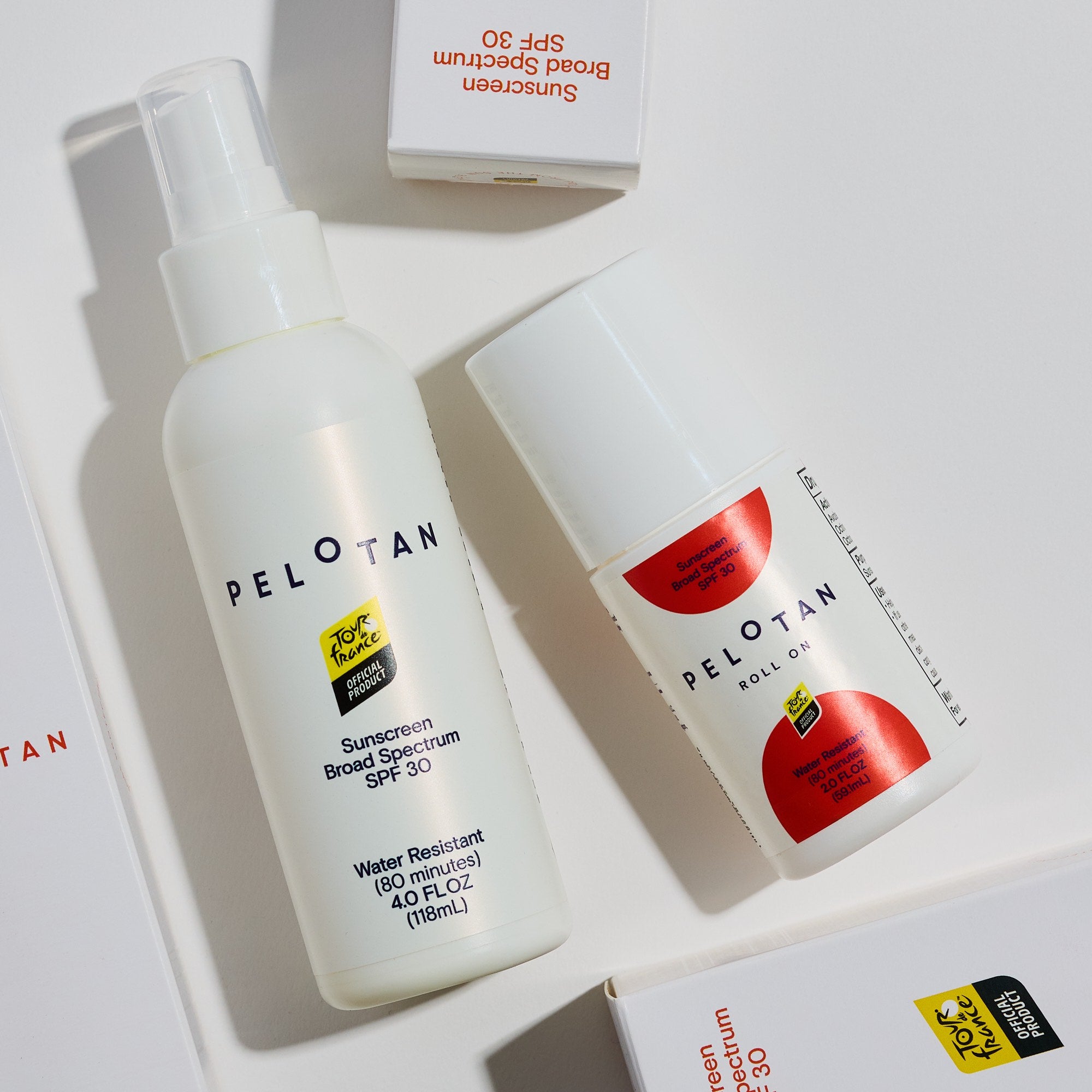 Two bottles of PELOTAN sunscreen with a box on a light gray background